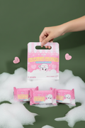 A hand holding Shaha Beauty Hakuji Gluta gift bag with 3 soap packs on army green background with foamy bubbles