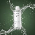 Anua Heartleaf 77+ Soothing Toner with dramatic water splashes on army green background